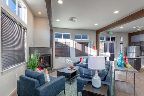 A modern living room with a fireplace and blue couches.