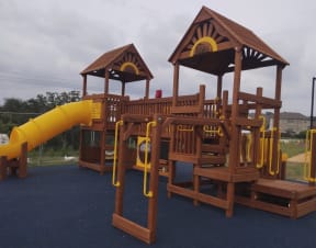a large wooden playset with a yellow slide