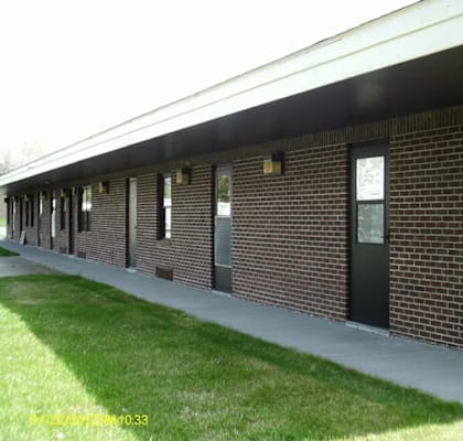 A long building with a black roof and windows.