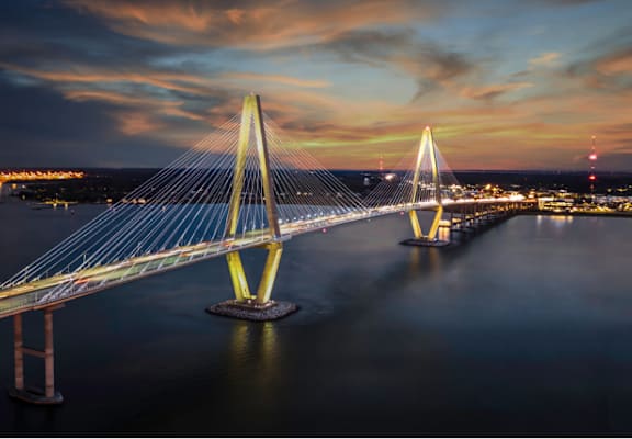 A bridge spans across a body of water at dusk.