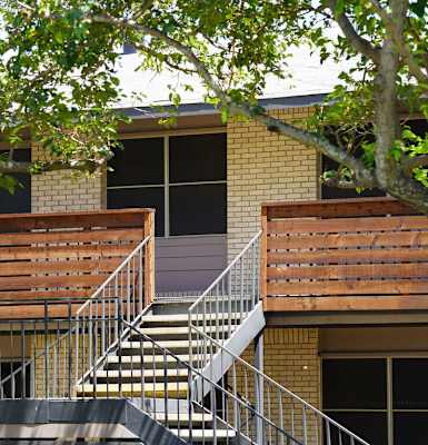 a building with stairs and a tree in front of it