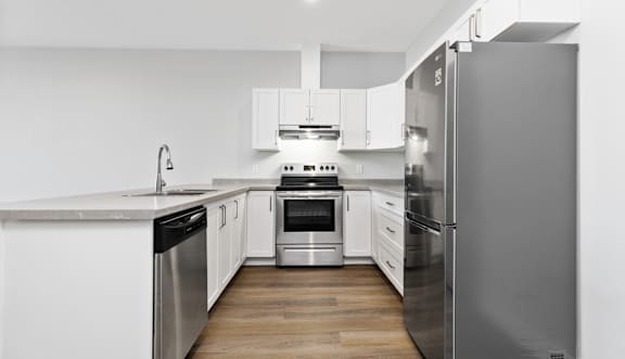A kitchen with white cabinets and stainless steel appliances.