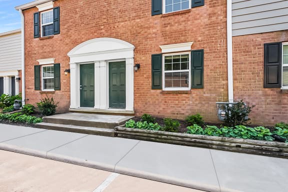 the front of the building with a sidewalk in front of it and a brick building behind it at Staples Mill Townhomes, Richmond, VA