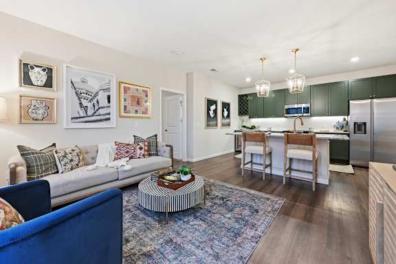 A modern living room with a blue sofa and a coffee table. at Maison Apartments, Westerville
