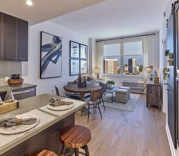 a kitchen and living room with a large window and a city view