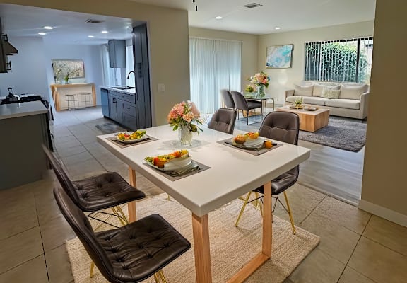 A dining room with a table set for four.