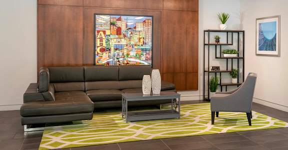 a lobby with couches and chairs and a painting on the wall