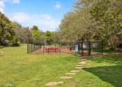 Thumbnail 11 of 14 - a dog park with a bench and a chain link fence