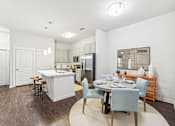 Thumbnail 29 of 31 - A kitchen with a dining table and chairs.