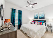 Thumbnail 26 of 31 - A bedroom with a white bed and a ceiling fan.
