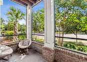 Thumbnail 30 of 31 - A balcony with a chair and a table.