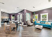 Thumbnail 16 of 31 - A living room with a purple wall and a blue couch.