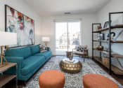 Thumbnail 4 of 35 - a living room with a blue couch and a large painting on the wall at East 51 At Rocketts Landing, Richmond, 23231