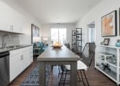 Thumbnail 7 of 35 - a kitchen and living room with white walls and wood flooring at East 51 At Rocketts Landing, Richmond, 23231