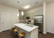 Thumbnail 16 of 30 - Kitchen with granite countertops and stainless steel appliances at Proximity Apartments, South Carolina, 29414