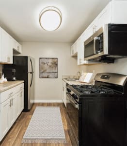 a kitchen with black appliances and white cabinets