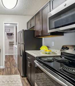 A kitchen with black appliances and a marble countertop.