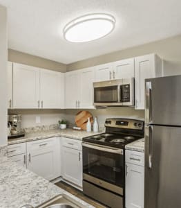 an open kitchen with stainless steel appliances and white cabinets