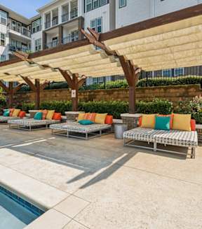 A pool area with a canopy and lounge chairs at Beckett Farms Apartments, PRG Real Estate Management, Fort Mill