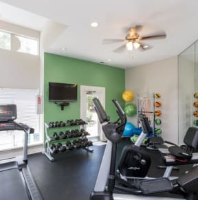 a home gym with exercise equipment and a ceiling fan