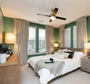 A bedroom with a bed, nightstand, chair, and a ceiling fan at Beckett Farms Apartments, PRG Real Estate Management, Fort Mill
