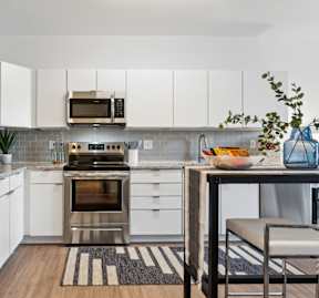 A modern kitchen with a stainless steel refrigerator, oven, and microwave.