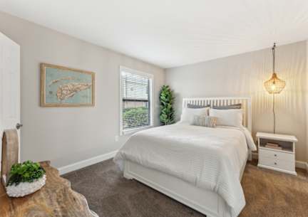 a bedroom with a bed and a window with blinds