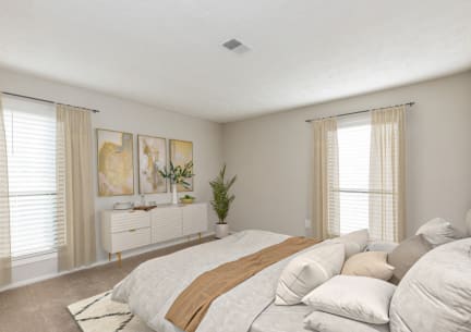 a bedroom with a large bed and two windows at Edgemont Apartments, PRG Real Estate, Greenville, 29615