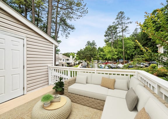 a balcony with a couch and a table and a garage