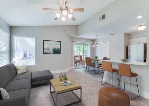 a living room with a couch and a coffee table in front of a dining area