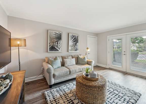 A living room with a grey couch and a woven coffee table.