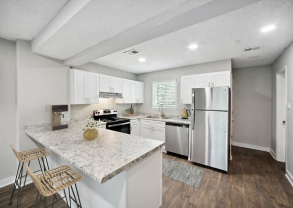 a kitchen with white cabinets and stainless steel appliances
