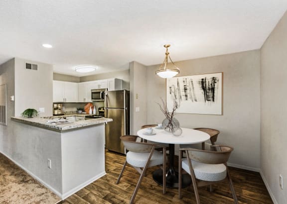 an apartment kitchen and dining area with a table and chairs