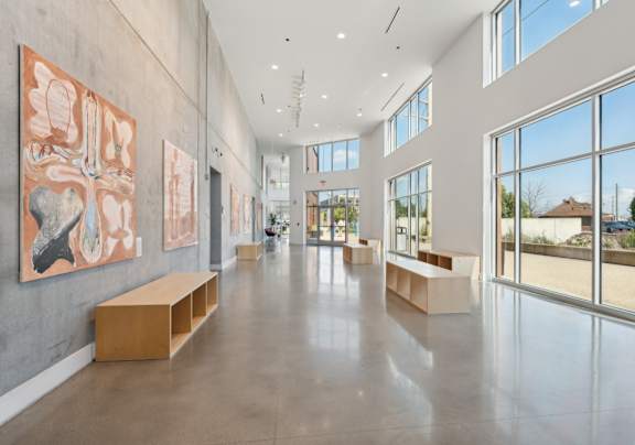 A spacious hallway with artwork on the walls and benches along the sides.