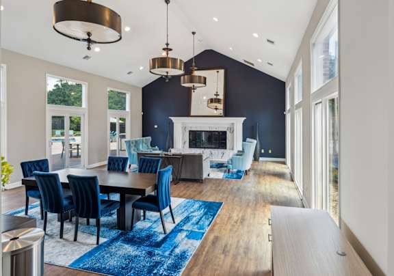 A modern dining room with a fireplace and blue chairs.