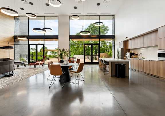 A modern kitchen with a dining table and chairs in the middle of the room.