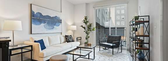 A modern living room with a white sofa, a grey armchair, and a coffee table.