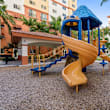 A playground with a blue slide and wooden structure.