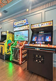 A room with a pinball machine and a basketball game. at Maison Apartments, Apartments, Westerville, OH