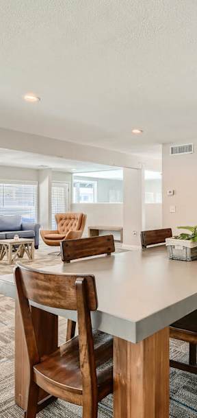 A kitchen with a dining table and chairs in the foreground.