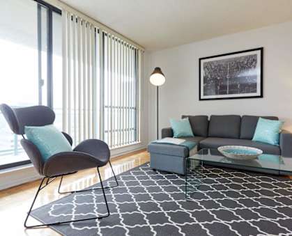 a living room with a couch and a chair in front of a window