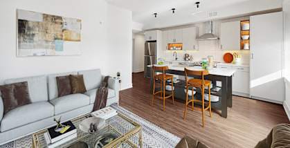a living room with a couch and a kitchen with a table and chairs