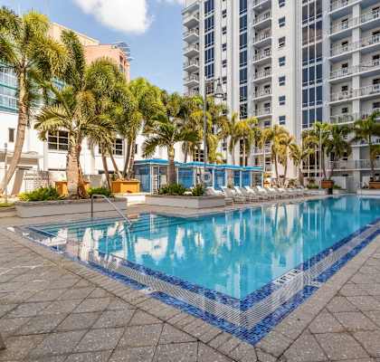 a large swimming pool with palm trees and a building in the background at Paramount on Lake Eola, Orlando, FL