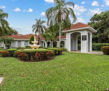 a fountain in the grass in front of a building at Cypress Shores, Coconut Creek, 33063