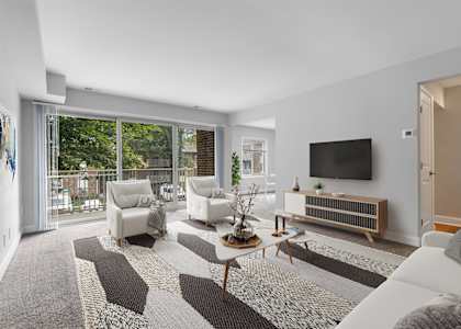 a living room with white furniture and a flat screen tv on the wall at Padonia Village Apartments, Timonium, MD