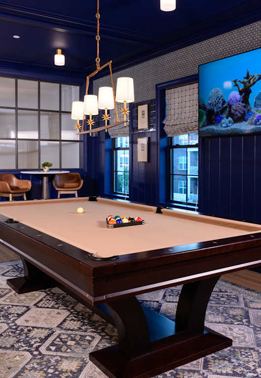 a lounge area with couches and a coffee table in front of a pool