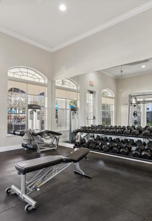 a woman sitting on the floor next to a dumbbell and water bottle at Grandeville on Saxon, Orange City, Florida
