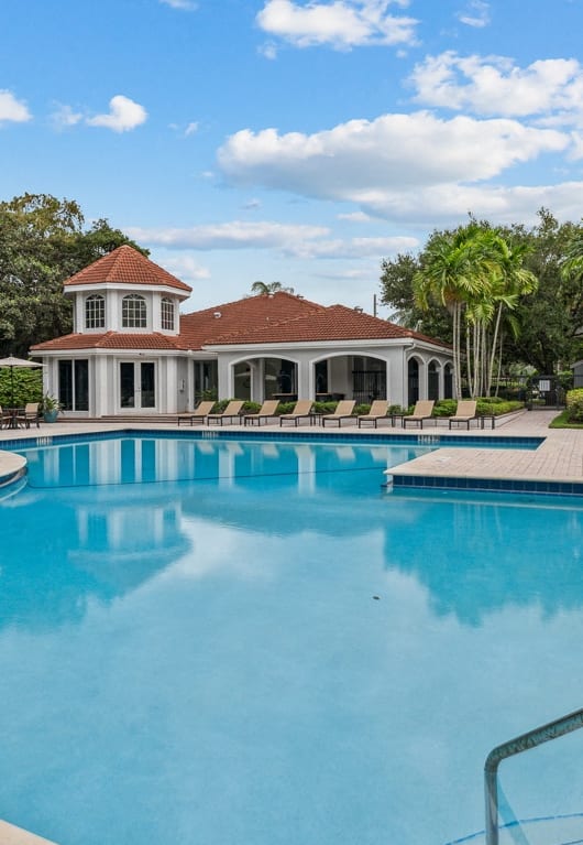 a large swimming pool with a house in the background at Cypress Shores, Coconut Creek, FL, 33063