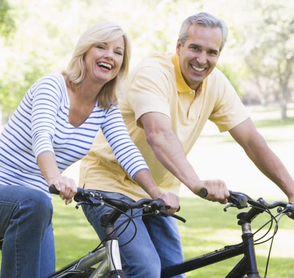 a man and a woman riding a bike  at Signature Pointe Apartment Homes, Athens