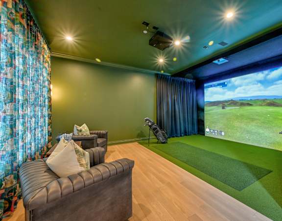 A room with a couch, a television, and a large screen showing a golf game.